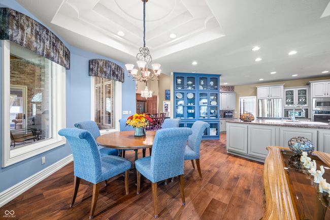 dining room featuring a chandelier, a tray ceiling, dark wood-style floors, baseboards, and recessed lighting | Image 27