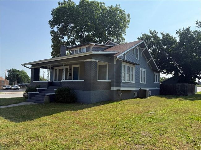 View of property exterior featuring central air condition unit, a lawn, covered porch, and brick siding | Image 30