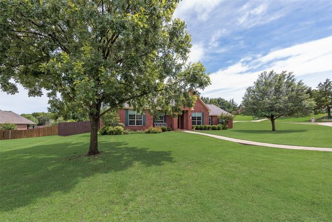 View of property hidden behind natural elements with brick siding | Image 6