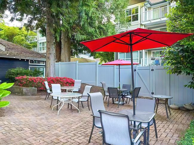 Fenced backyard with a gate, outdoor dining space, and a patio area | Image 11