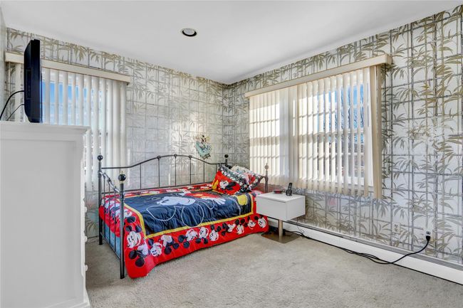 Bedroom with a baseboard heating unit and carpet floors | Image 24