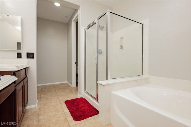 Full bath with vanity, baseboards, a shower stall, tile patterned floors, and a bath | Image 25
