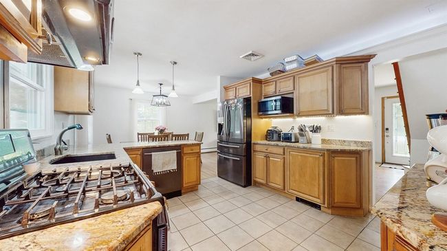 Huge Kitchen with lots of large Oak Cabinets, Stainless Steel Appliances, light stone Granite Counters, light ceramic tile patterned Floors, and Pendant Lighting. | Image 14