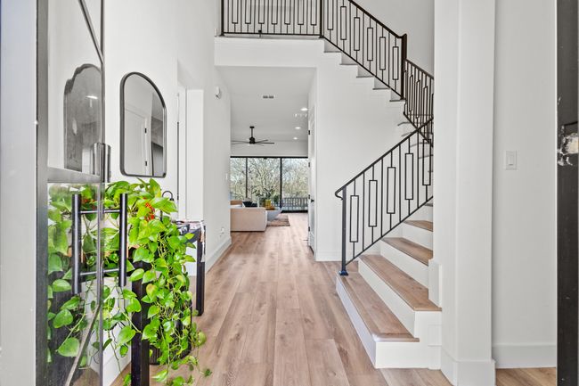 Entrance foyer featuring wood finished floors, a ceiling fan, a high ceiling, and stairs | Image 13