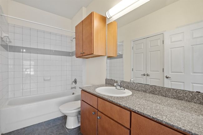 Bathroom featuring shower / washtub combination, vanity, and dark tile patterned floors | Image 19