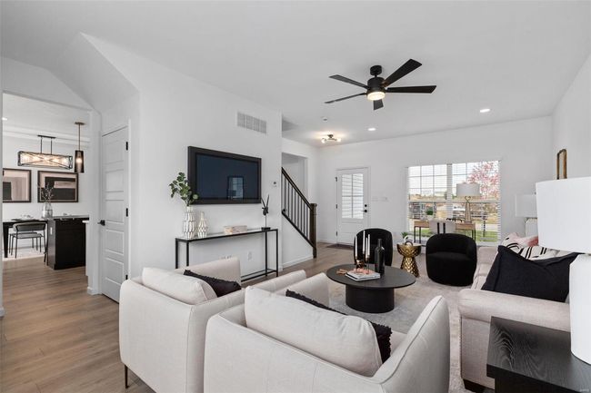 Living room with ceiling fan with notable chandelier and wood-type flooring | Image 7