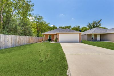 Single story home featuring a front lawn and a garage | Image 1