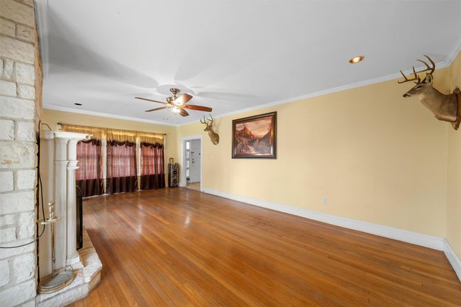 Spare room with ornamental molding, wood-type flooring, and ceiling fan | Image 6