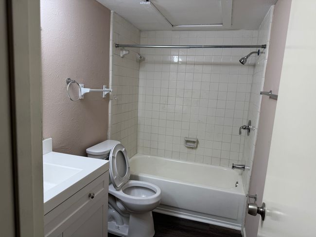 Full bath with vanity, tub / shower combination, wood finished floors, and a textured wall | Image 7