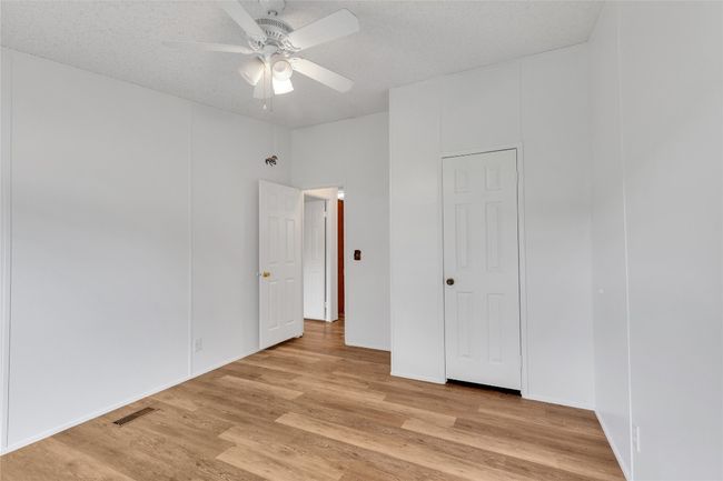 Unfurnished bedroom with light wood-type flooring and ceiling fan | Image 21
