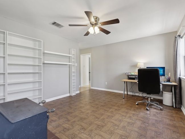 Office area with baseboards, a ceiling fan, and visible vents | Image 18
