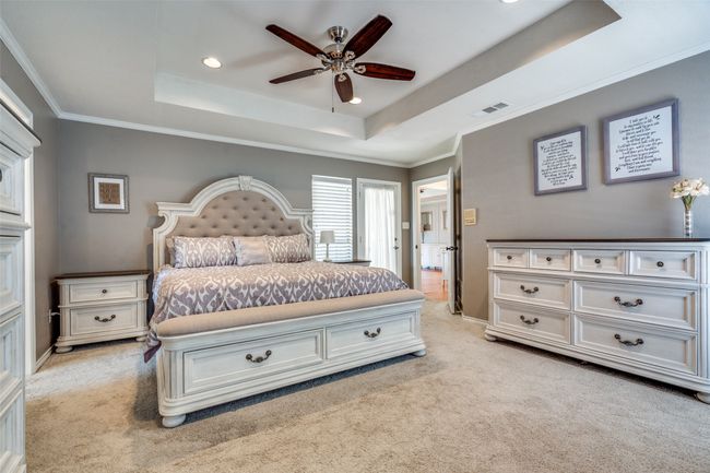 Bedroom with light colored carpet, a raised ceiling, recessed lighting, ceiling fan, and crown molding | Image 23