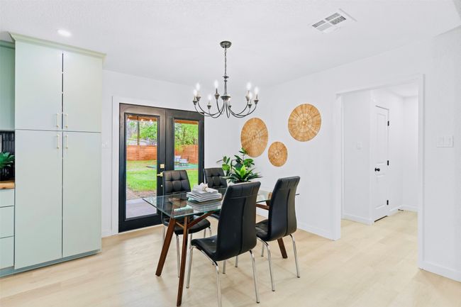 Dining space featuring light wood-type flooring, a chandelier, and french doors | Image 10