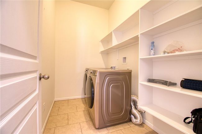 Clothes washing area featuring independent washer and dryer, laundry area, baseboards, and light tile patterned floors | Image 8