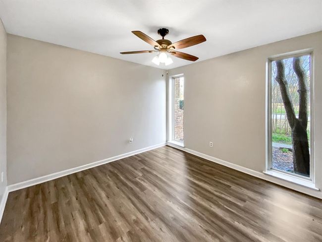 Formal dining room with tall windows, filling the space with natural light. | Image 4