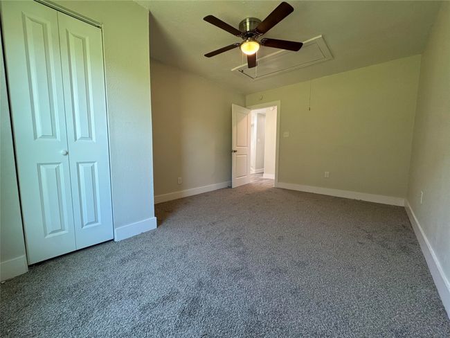 Unfurnished bedroom featuring a closet, baseboards, attic access, a ceiling fan, and carpet floors | Image 20