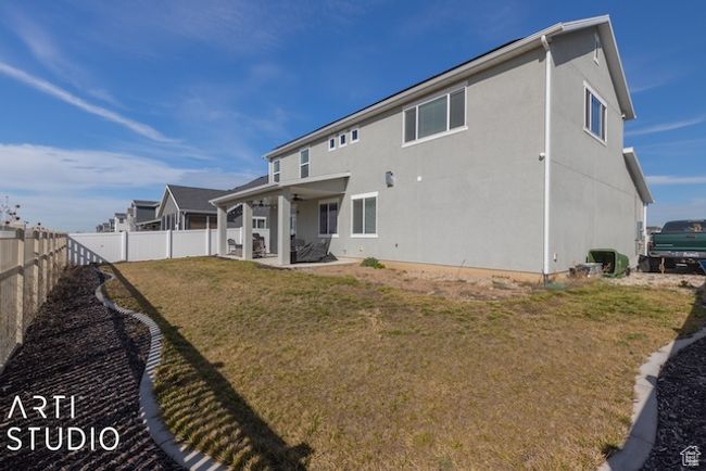 Rear view of property featuring a patio, a fenced backyard, a lawn, and stucco siding | Image 47