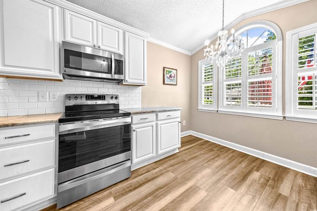 Kitchen with crown molding, appliances with stainless steel finishes, a wealth of natural light, and light wood-type flooring | Image 20