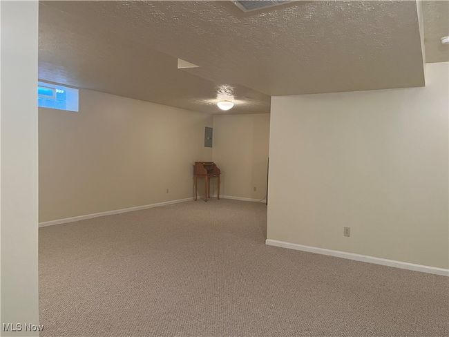 Below grade area featuring a textured ceiling, carpet, and electric panel | Image 20