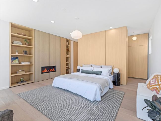 Bedroom with light wood-type flooring, a fireplace, and recessed lighting | Image 21