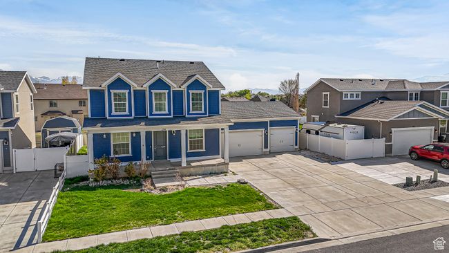 Traditional-style home featuring a front yard, a garage, a residential view, a gate, and driveway | Image 50