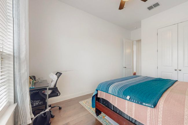 Bedroom with a closet, baseboards, visible vents, ceiling fan, and wood finished floors | Image 21