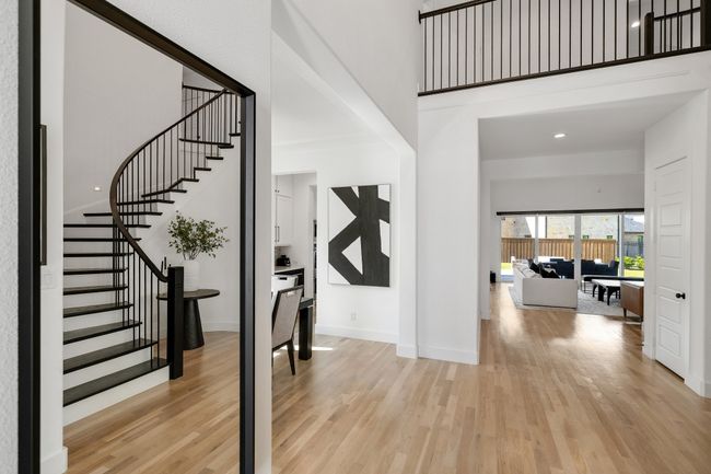 Entryway featuring light wood-style floors, stairs, a towering ceiling, and baseboards | Image 4
