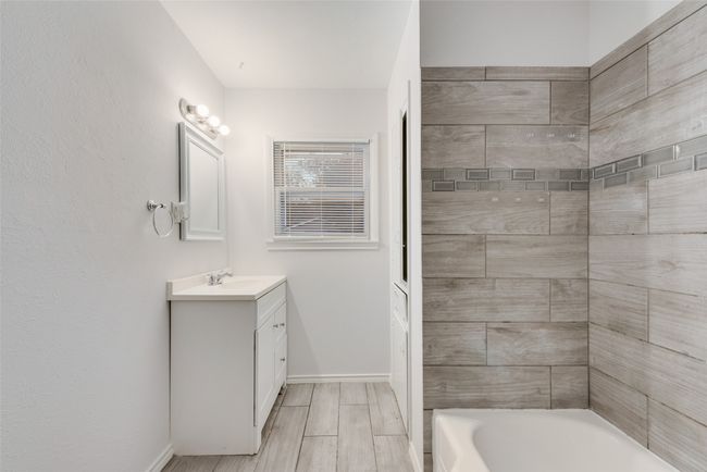 Full bath featuring baseboards, vanity, and wood tiled floor | Image 9