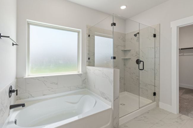 Bathroom with a bath, a stall shower, marble look tiles, recessed lighting, and a walk in closet | Image 14