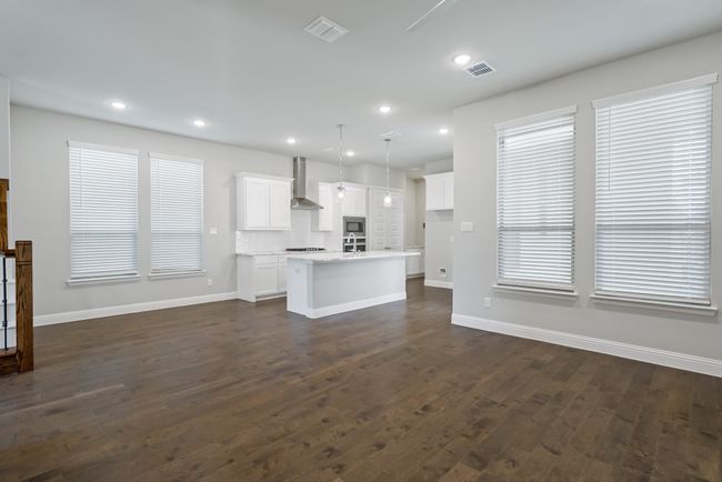 Unfurnished living room with baseboards, visible vents, recessed lighting, and dark wood-type flooring | Image 10