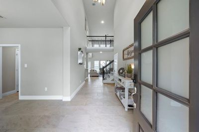 Spacious Modern Entry with high ceilings, tile flooring, that features a nuetral color palette. This entry offers a glimpse into the home and showing the the Formal dining room directly to the left w/a door into the Kitchen | Image 3