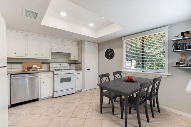 Kitchen with stainless steel dishwasher, gas range gas stove, ventilation hood, white cabinetry, and recessed lighting | Image 5