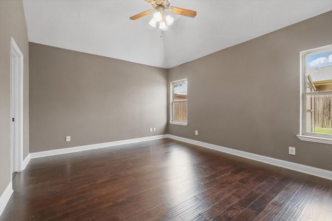 Spare room featuring a ceiling fan, baseboards, dark wood-style flooring, and lofted ceiling | Image 17