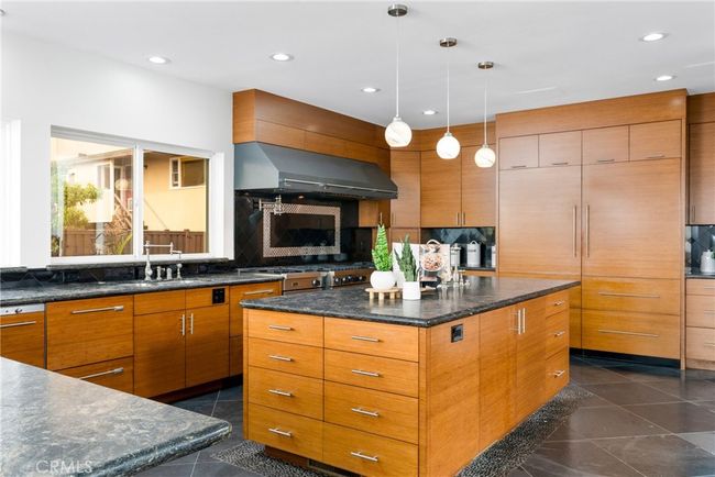 Stainless steel professional Viking gas range with 8 burners, a griddle, wok system, double oven, custom range hood, and pot filler. | Image 13