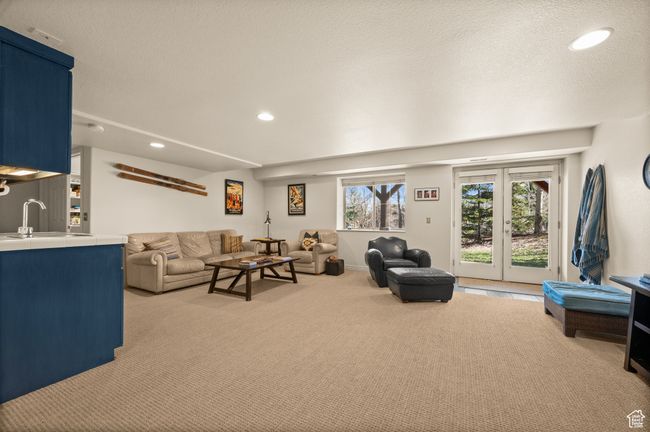 Carpeted living area featuring recessed lighting, bar, and a sink | Image 26