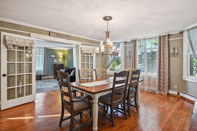 The formal dining room—if walls could talk! This room has the original hardwood floors and beautiful French doors that separate it from the living room. It has recently been painted, and the light fixture has been upgraded. | Image 33