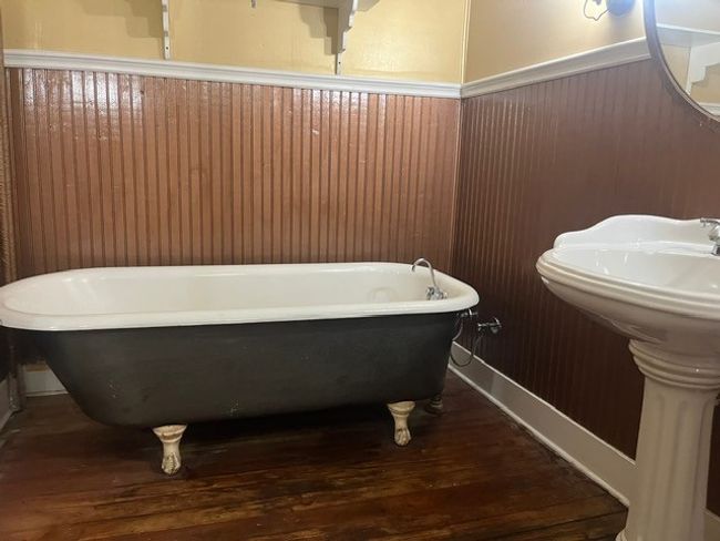 Bathroom featuring wood finished floors, a freestanding tub, and a wainscoted wall | Image 23