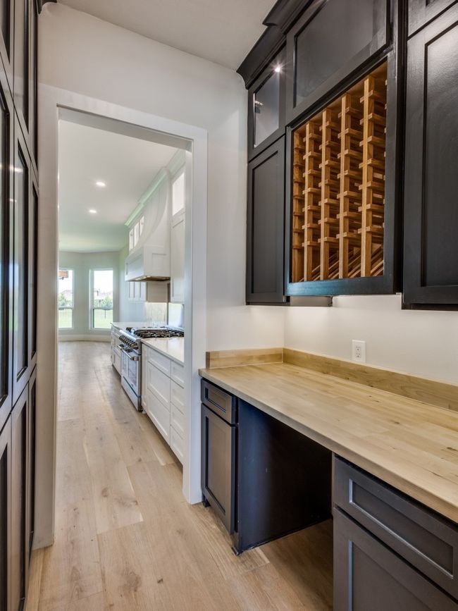 Kitchen featuring high end range, light wood-type flooring, premium range hood, recessed lighting, and glass insert cabinets | Image 27
