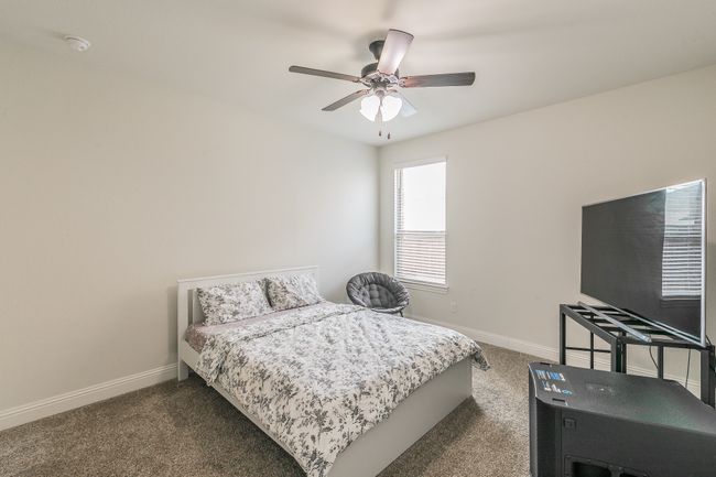 Bedroom featuring dark carpet, a ceiling fan, and baseboards | Image 12
