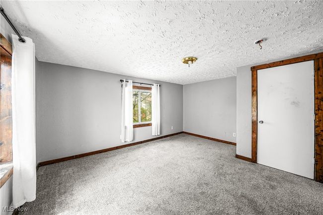 Carpeted empty room with a textured ceiling | Image 12