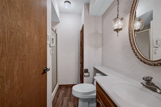 Bathroom with baseboards, toilet, a textured ceiling, vanity, and wood finished floors | Image 30