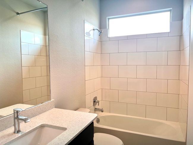 Bathroom with a textured wall, vanity, and shower combination | Image 17