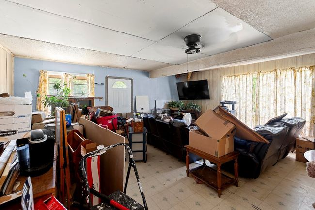 Living area with light floors and a ceiling fan | Image 9