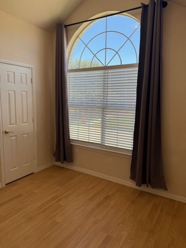 Unfurnished room with healthy amount of natural light, light wood-type flooring, and vaulted ceiling | Image 18