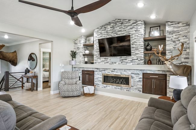 Living area with a fireplace, ceiling fan, vaulted ceiling, and wood finished floors | Image 12
