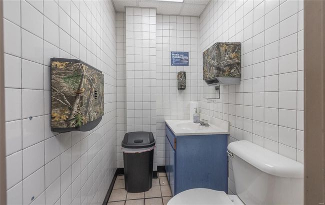Bathroom with vanity, tile walls, tile patterned floors, and toilet | Image 11