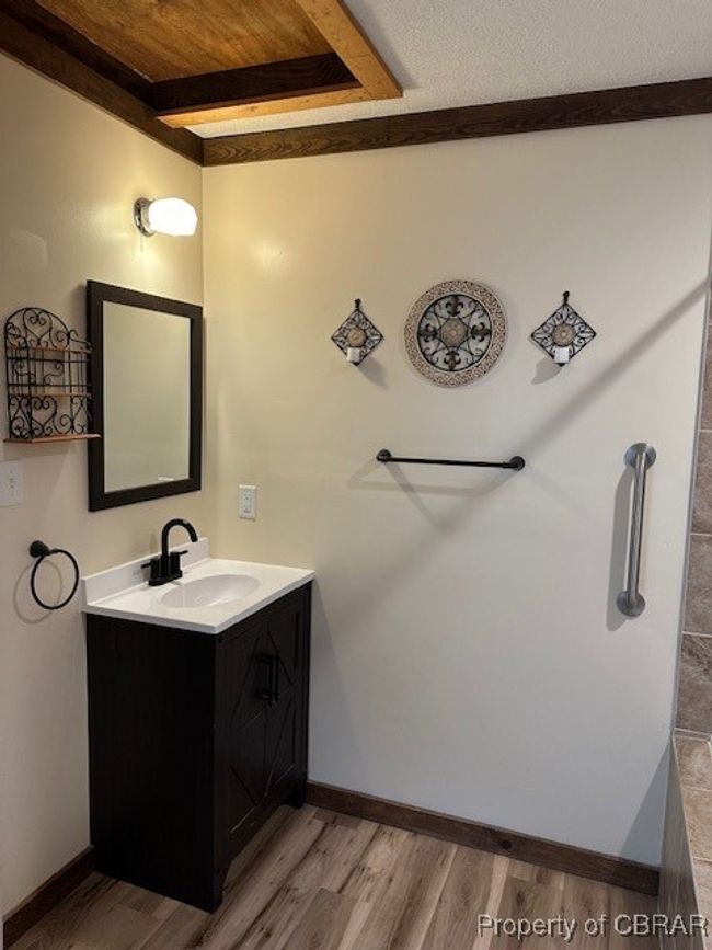 Bathroom with vanity, wood finished floors, beamed ceiling, and baseboards | Image 14