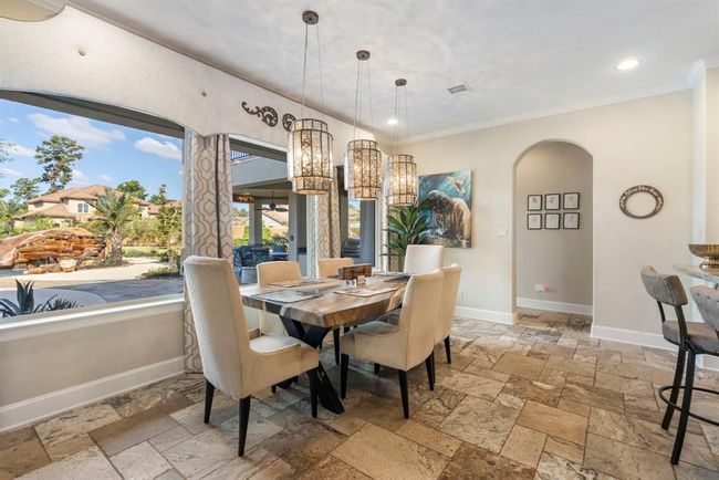 Sunlit Dining Space: Enjoy tranquil views in this elegantly appointed nook, perfect for morning coffee and intimate meals. | Image 15