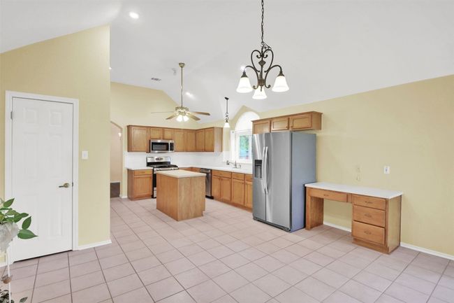 Breakfast area featuring appliances with stainless steel finishes, a kitchen island, light countertops, a ceiling fan, and pendant lighting | Image 20