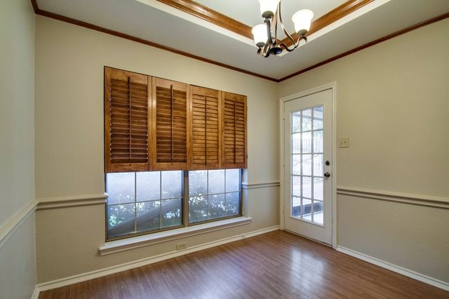 Spare room with a chandelier, wood finished floors, and ornamental molding | Image 14